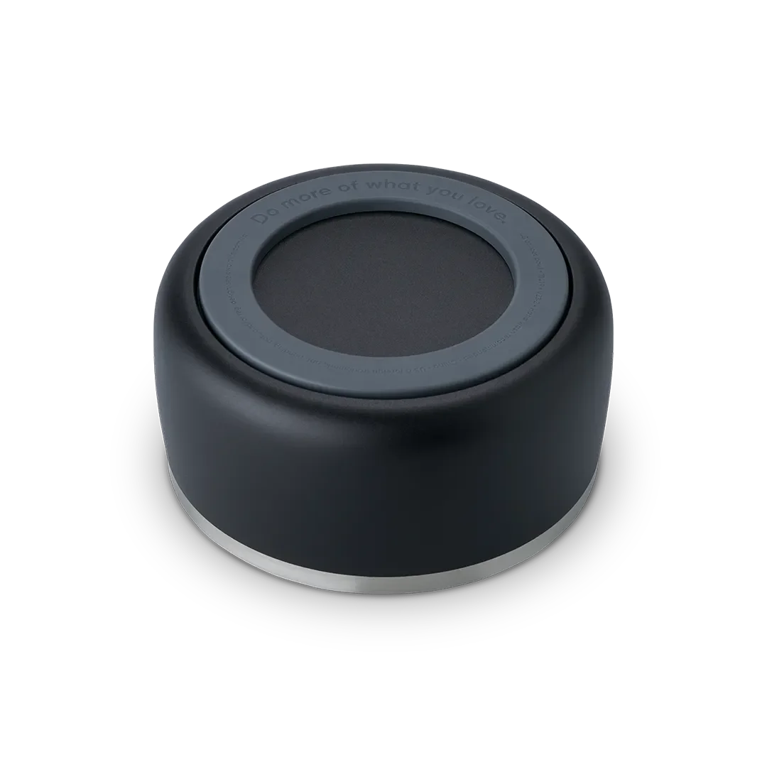 Owala Pet Bowl, bottom view showing black silicone cup exterior with dark gray accent ring embossed with "Do more of what you love" and thin stainless steel band at rim