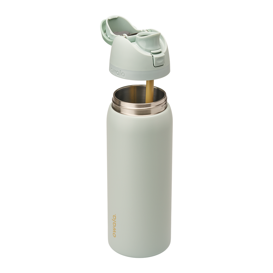 Owala FreeSip 32oz in Summer Paradise, exploded view with sage green insulated stainless steel body open at the top revealing the stainless interior, lid assembly separated above showing mint green flip cap open and gold-toned straw